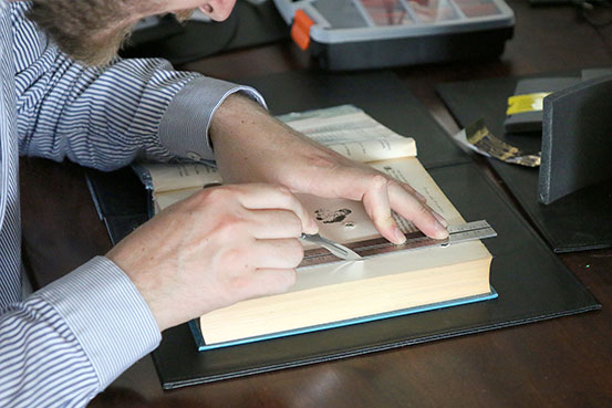 Maz cutting pages from the book