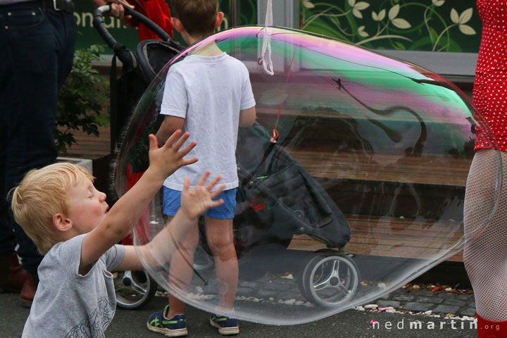 A young boy eats Miss Bubbles’ huge bubble at the Paddington Christmas Fair