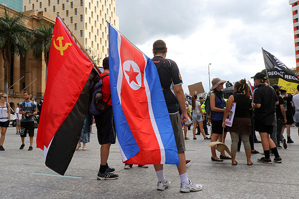 The communists hammer home their message of inclusion and peace by bringing a North Korean flag