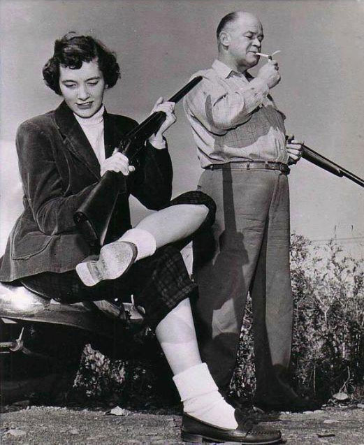 A woman inadvertently points a gun towards a man.