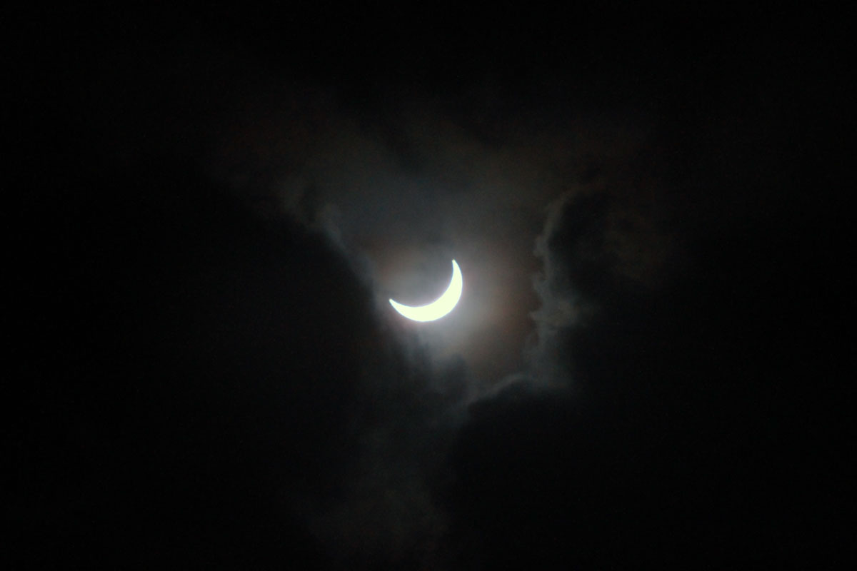 The sun shows through a hole, partially eclipsed