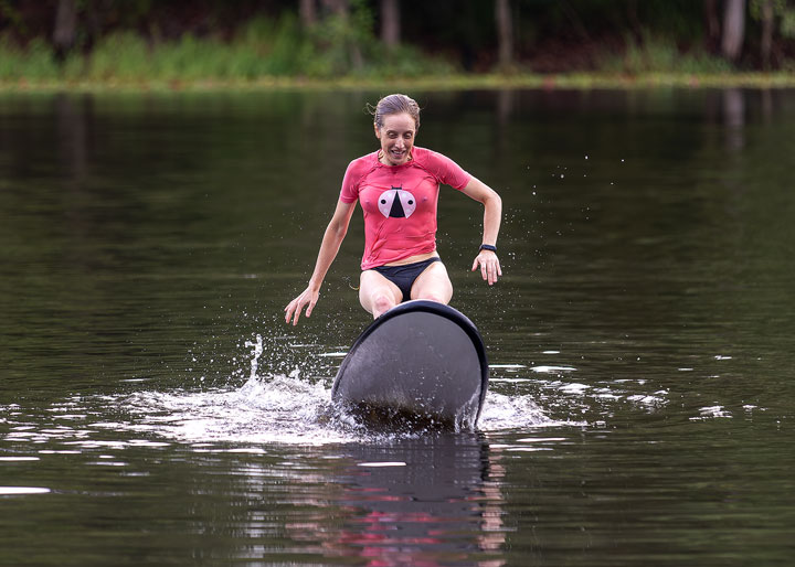 Bronwen trying to stand on a foam surfboard at Enoggera Reservoir