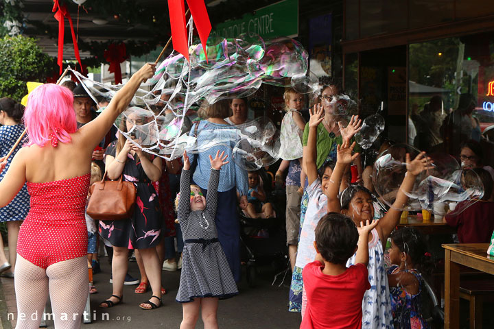 Miss Bubbles showering children in bubbles at the Paddington Christmas Fair