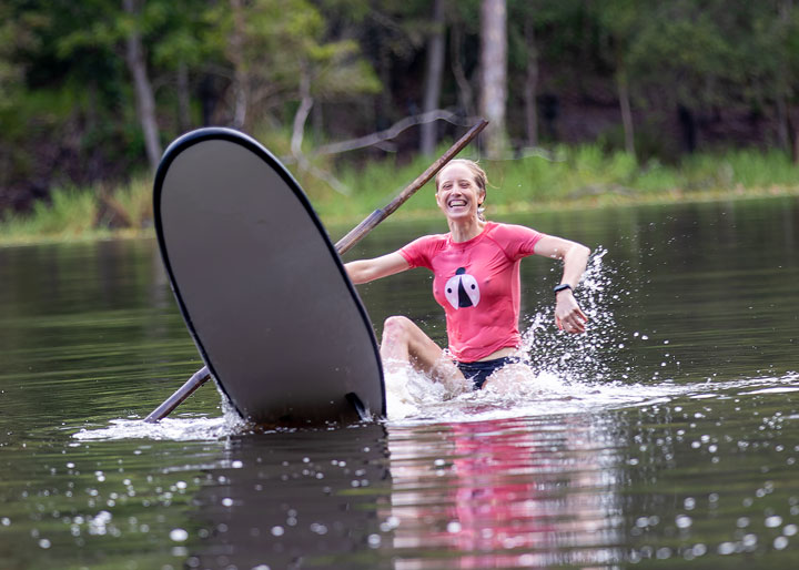 Bronwen trying to stand on a foam surfboard at Enoggera Reservoir