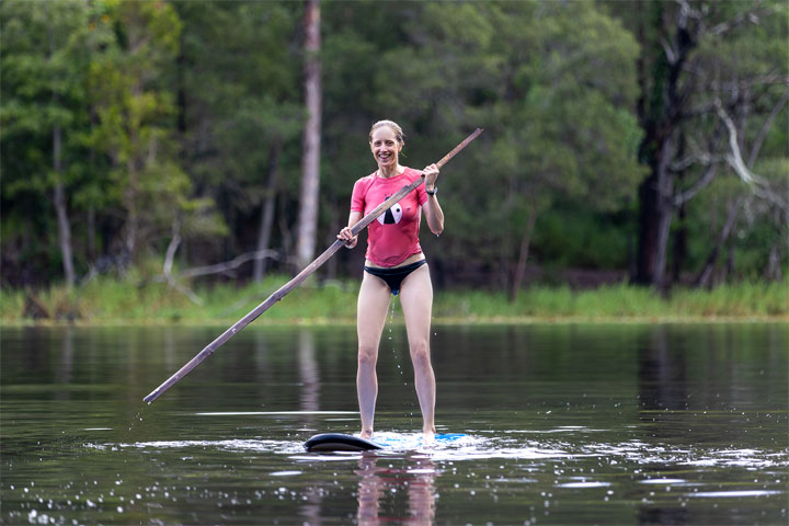 Bronwen trying to stand on a foam surfboard at Enoggera Reservoir