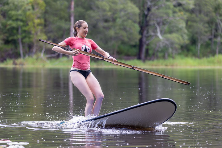 Bronwen trying to stand on a foam surfboard at Enoggera Reservoir