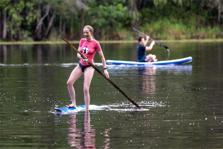 Bronwen trying to stand on a foam surfboard at Enoggera Reservoir