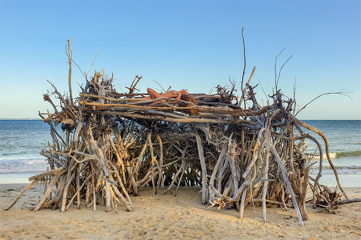 Bronwen climbing on a driftwood hut, Woody Bay, Bribie Island