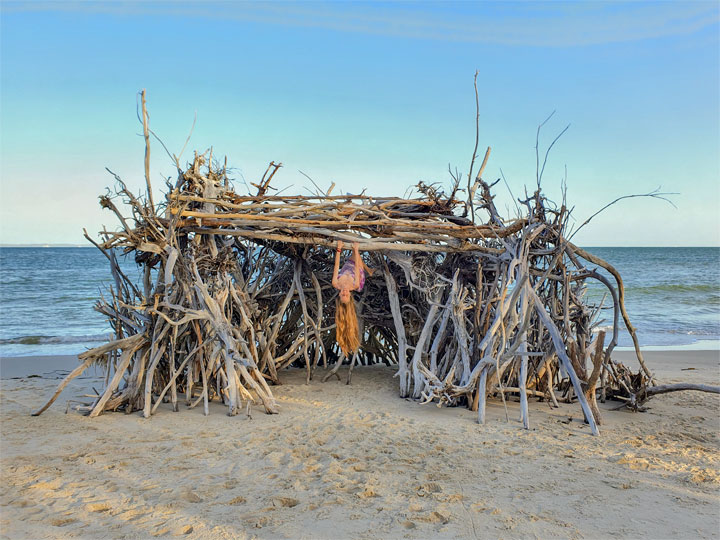 Bronwen climbing on a driftwood hut, Woody Bay, Bribie Island