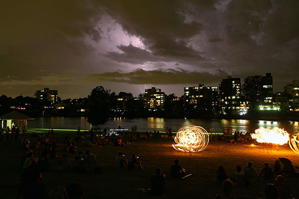 A storm gathers behind the fire twirlers