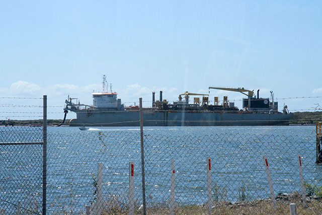 A large dredge offloading sand for the new runway