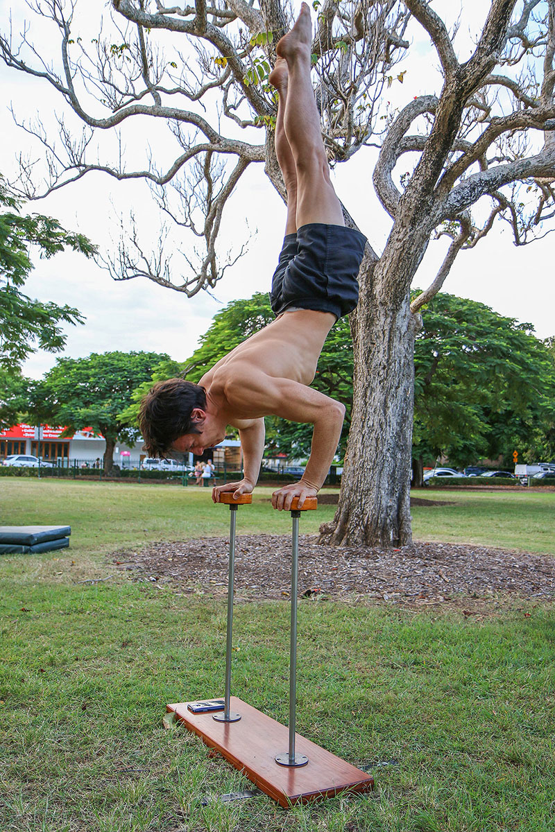 A man leans on some sticks