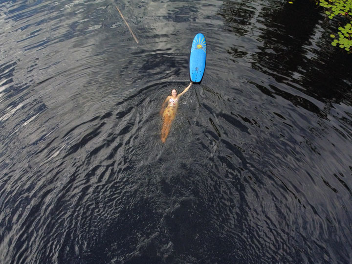 Bronwen trying to stand on a foam surfboard at Enoggera Reservoir