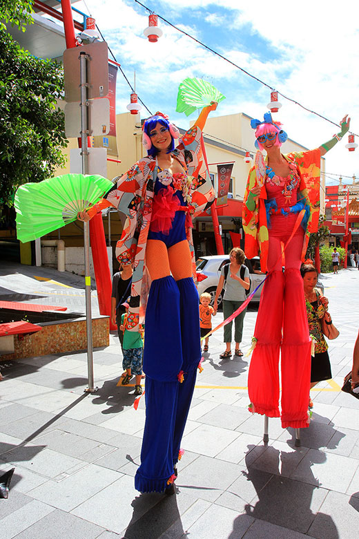 Stiltwalkers in Asian garb