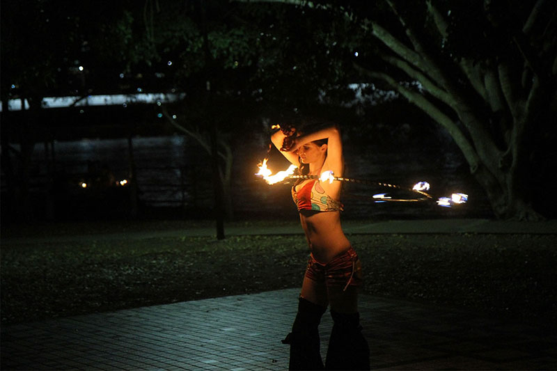 A girl plays with fire at Sunset Gathering