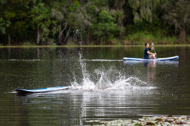 Bronwen trying to stand on a foam surfboard at Enoggera Reservoir