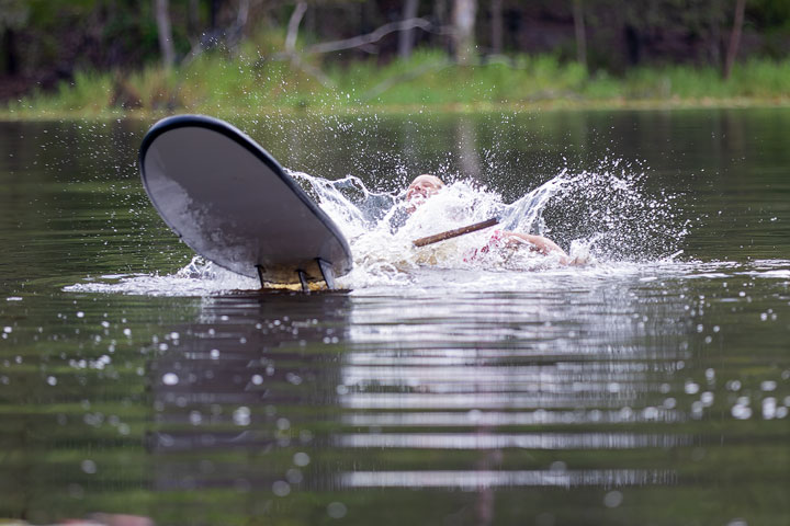 Bronwen trying to stand on a foam surfboard at Enoggera Reservoir