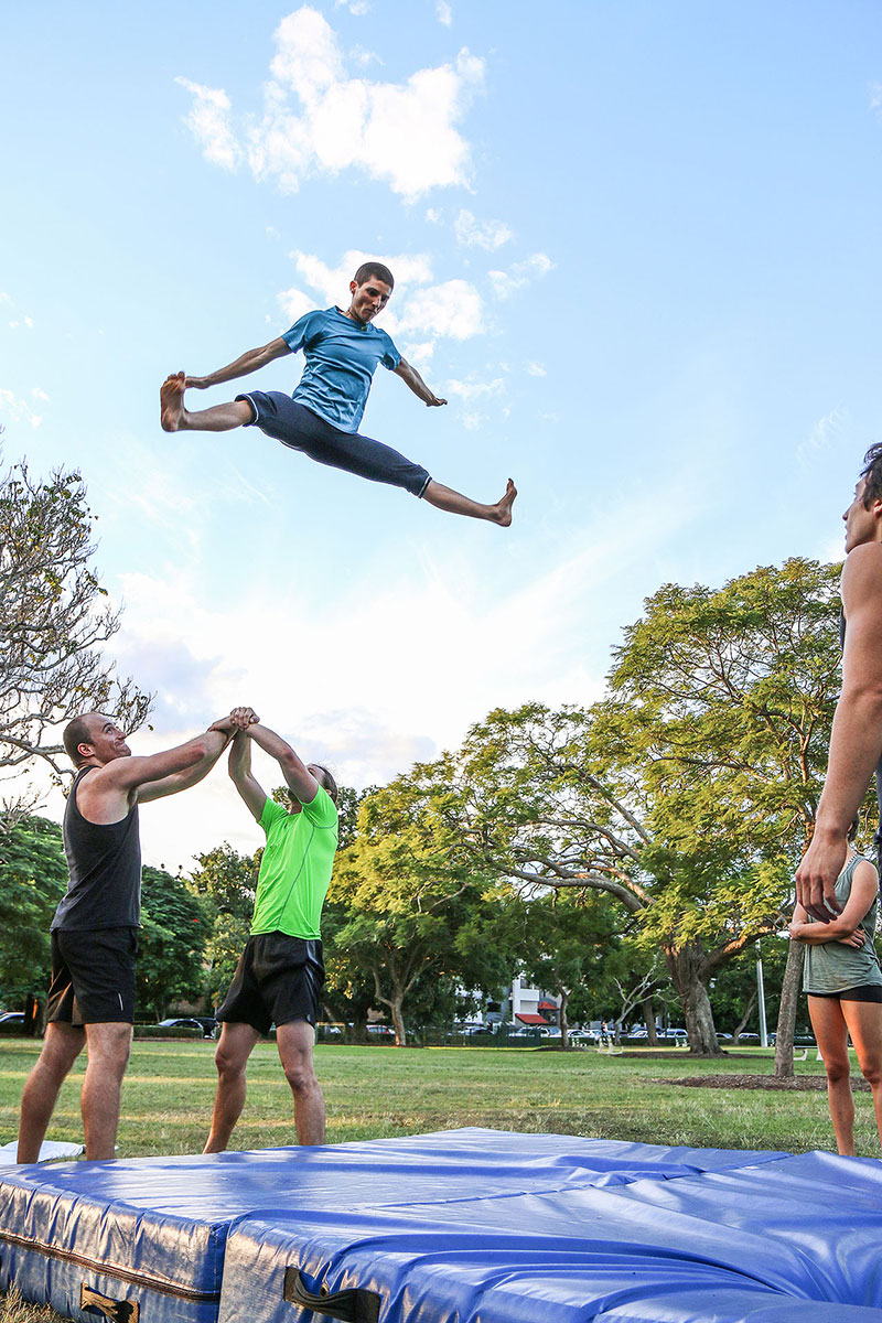 A woman does the splits above two men