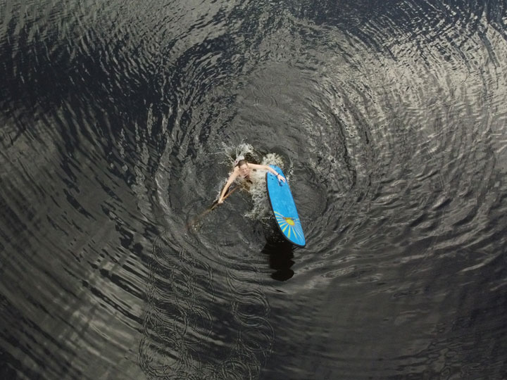 Bronwen trying to stand on a foam surfboard at Enoggera Reservoir