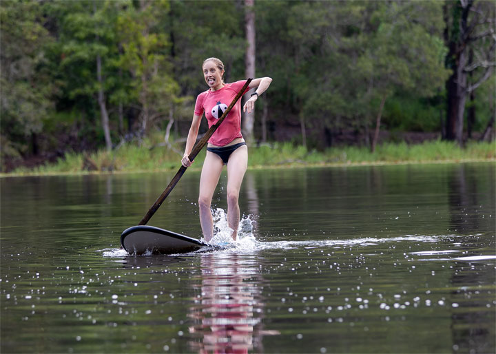 Bronwen trying to stand on a foam surfboard at Enoggera Reservoir