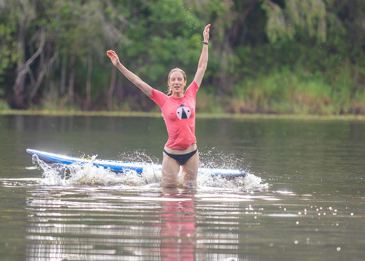 Bronwen trying to stand on a foam surfboard at Enoggera Reservoir