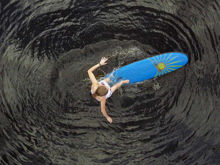 Bronwen trying to stand on a foam surfboard at Enoggera Reservoir