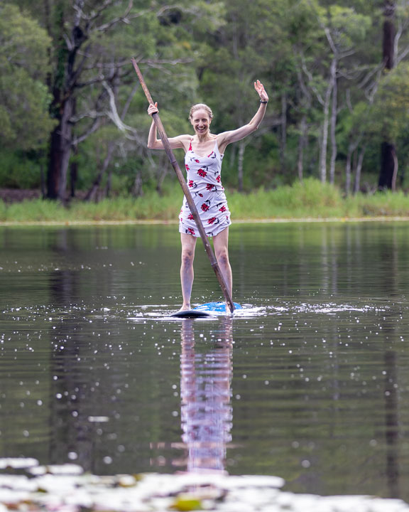 Bronwen trying to stand on a foam surfboard at Enoggera Reservoir