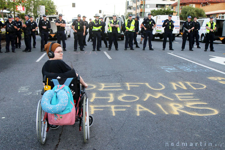 A protester tries to hold off the police