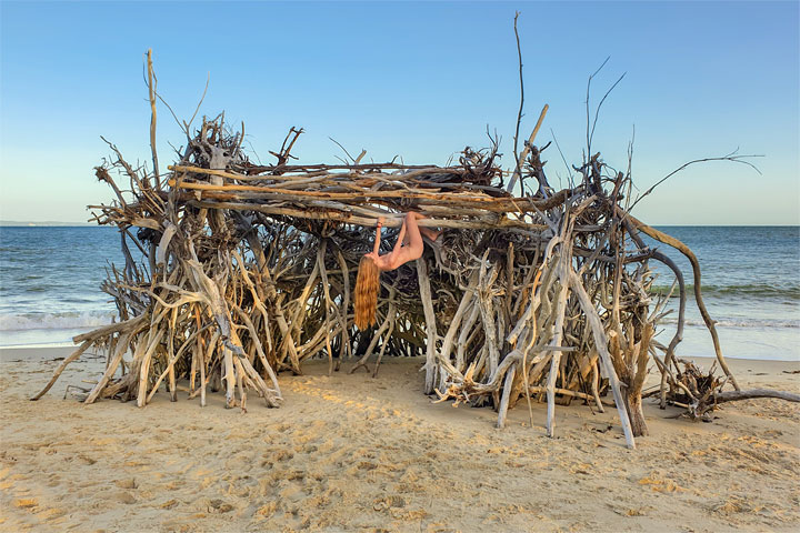 Bronwen climbing on a driftwood hut, Woody Bay, Bribie Island