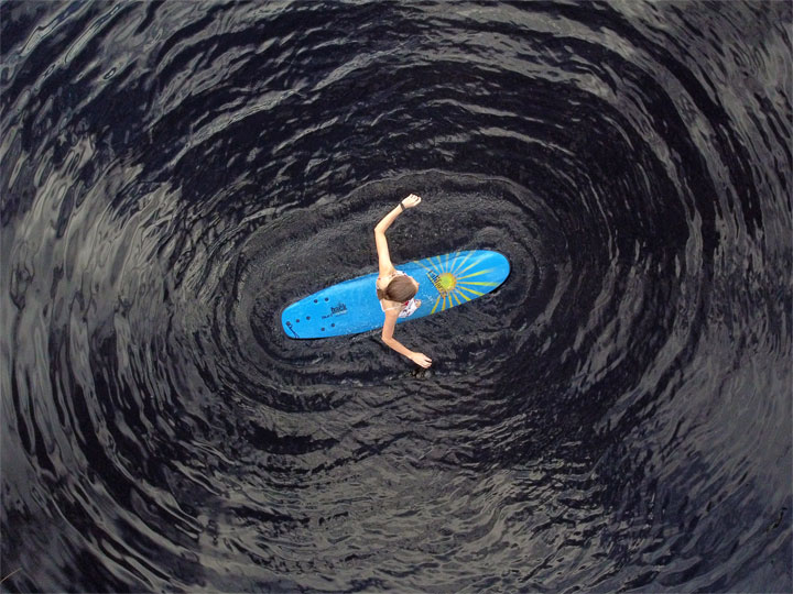 Bronwen trying to stand on a foam surfboard at Enoggera Reservoir