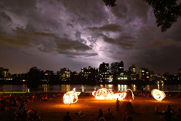 Fire twirling in front of a storm