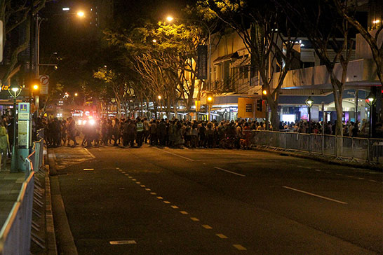 People rush across a street after it is opened