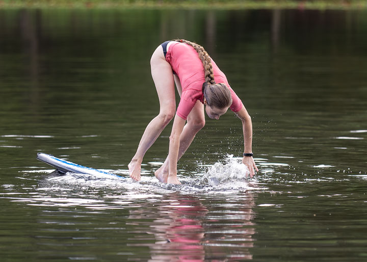 Bronwen trying to stand on a foam surfboard at Enoggera Reservoir