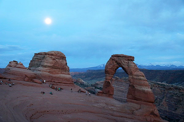 The moon rises over Delicate Arch.