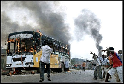 Boy throwing a VCR at a burning bus