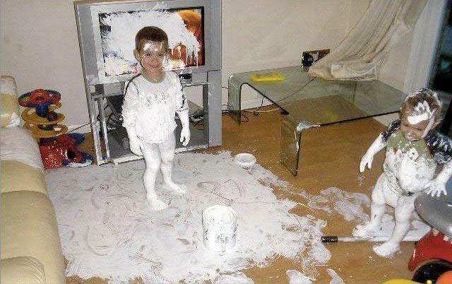 Two children, half a room and a TV covered in white paint.