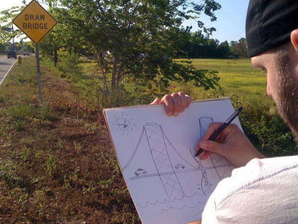 A man drawing a bridge at a “draw bridge” sign