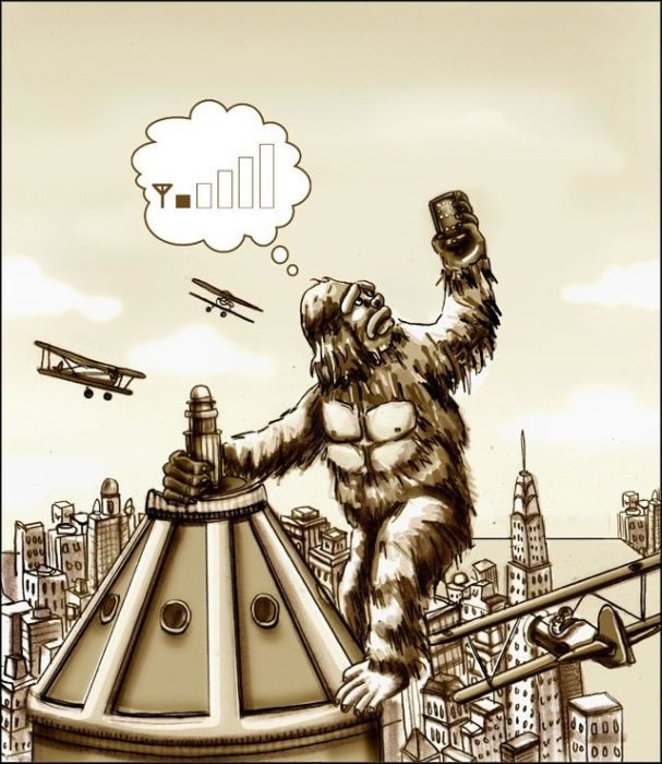 King Kong holds aloft a mobile phone, trying to get signal