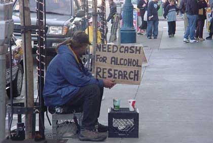 Image of man holding cardboard sign "Need Cash for Alcohol Research"