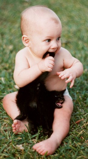Image of a baby chewing on a cat’s tail