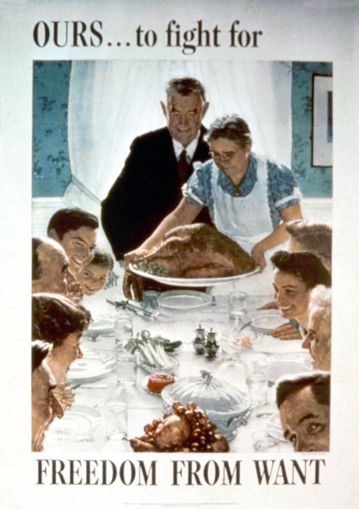 A family sits around the dinner table as an older woman brings out a turkey