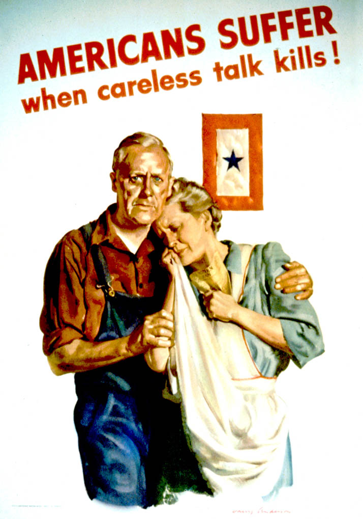 A husband holds his crying wife while a service flag hangs in the background