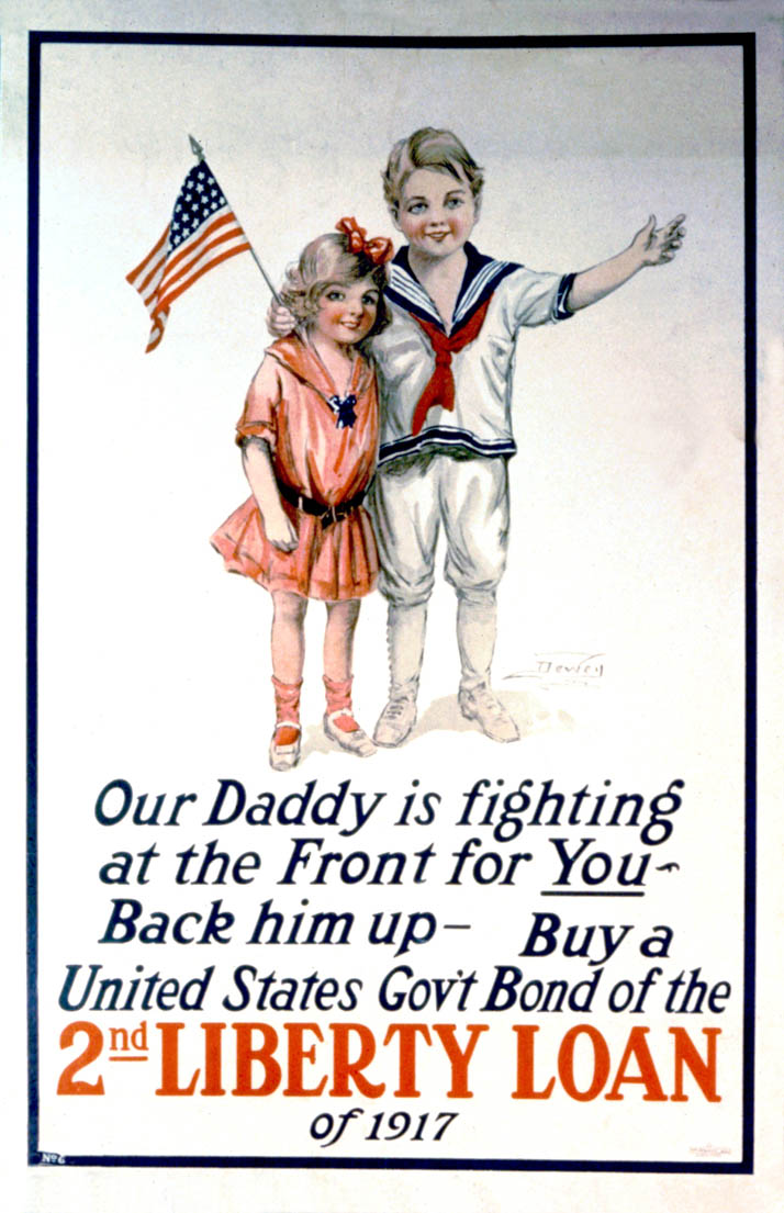 A young boy and girl stand smiling while waving an American flag