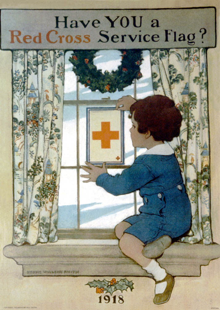 A young boy places a service flag in the window